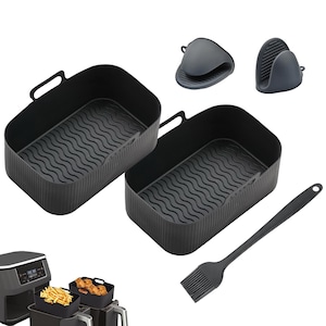 May include: Black silicone air fryer accessories set. Includes two rectangular baskets with wavy bases, two oven mitts, and a basting brush. The air fryer is shown with food inside the baskets.