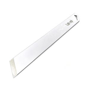 Puede incluir: Una herramienta plana, rectangular y plateada con una punta puntiaguda y un borde biselado. La herramienta tiene la palabra japonesa "山野" grabada en ella.