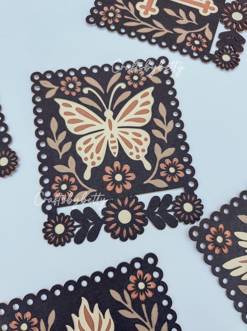 May include: Close-up of several dark brown, square-shaped paper cutouts with a scalloped edge. Each cutout features a butterfly and floral design in shades of tan and brown. The text "Crafts by Betty" is visible.