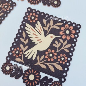May include: Laser-cut wooden decorative pieces featuring a bird and floral design. The bird is light beige, surrounded by brown leaves and peach-colored flowers, set against a dark brown background. The edges have a scalloped design. The text "Crafts by betty" is visible.