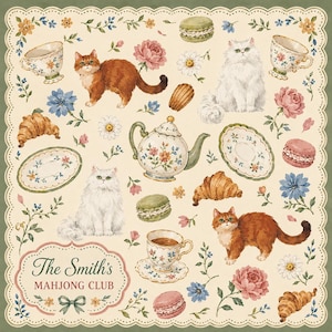Pode incluir: Um tecido quadrado de cor creme com uma borda verde recortada e um padrão de gatos laranja e brancos, chávenas de chá florais, bules, croissants, macarons e flores. Uma etiqueta decorativa apresenta o texto The Smith's MAHJONG CLUB.