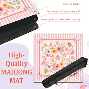 May include: A high-quality Mahjong mat with a coastal theme. The mat features a pink and white striped border and a central design of seashells, flowers, and a compass rose. It has a non-slip rubber foam backing and comes with a black carrying case.