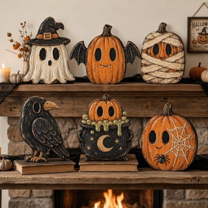 May include: A collection of six Halloween-themed wooden decorations including a ghost in a witch hat, a bat-winged pumpkin, a mummy pumpkin, a black raven, a pumpkin in a cauldron with a crescent moon, and a pumpkin with a spider web design.