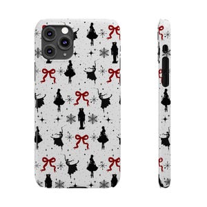 Puede incluir: Una funda de iPhone blanca con un patrón repetido de siluetas negras de bailarinas, cascanueces, copos de nieve y lazos rojos.