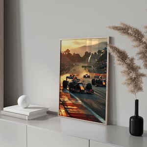 Puede incluir: Una fotografía enmarcada de un coche de Fórmula Uno que acelera por una pista al atardecer. El coche es rojo y blanco con detalles negros. La pista está bordeada de espectadores y el sol se pone en el fondo.