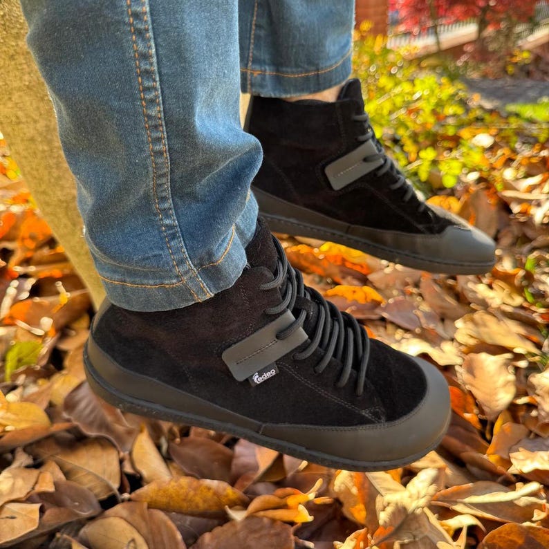 Pu&ograve; includere: Sneakers nere alte con lacci neri e un cinturino nero sulla parte superiore. Le sneakers hanno una suola in gomma nera e sono in pelle scamosciata. Il nome del marchio "Gaileo" &egrave; visibile sul cinturino.
