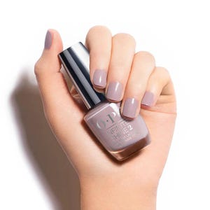 May include: A hand holding a bottle of O.P.I. Infinite Shine 2 nail lacquer in the shade "In Lace With You". The bottle is a light brown color with a silver cap.