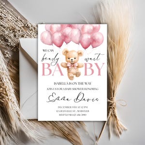 May include: A pink and white baby shower invitation with a teddy bear holding pink balloons. The text reads "We can bearly wait BABY" and "Isabella is on the way".