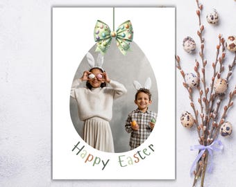 May include: A Happy Easter card with a photo of two children wearing bunny ears and holding Easter eggs. The card has a green and white bow at the top and the words "Happy Easter" in a green, white, and brown font.