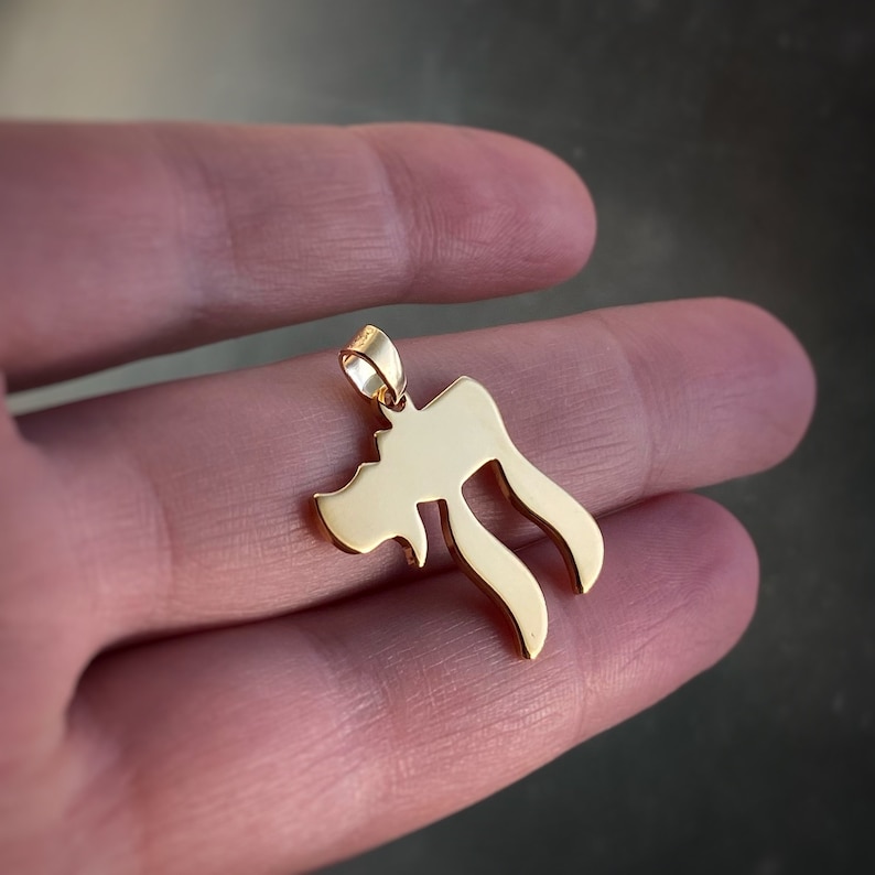 Peut inclure: Un pendentif en forme de lettre h&eacute;bra&iuml;que Chai, symbole de vie, de couleur dor&eacute;e.
