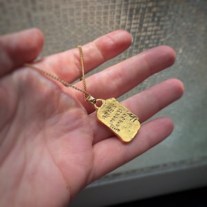 Pu&ograve; includere: Collana d'oro con un ciondolo a forma di etichetta rettangolare. L'etichetta ha le parole "Aries" e "March 21 - April 19" incise su di essa.