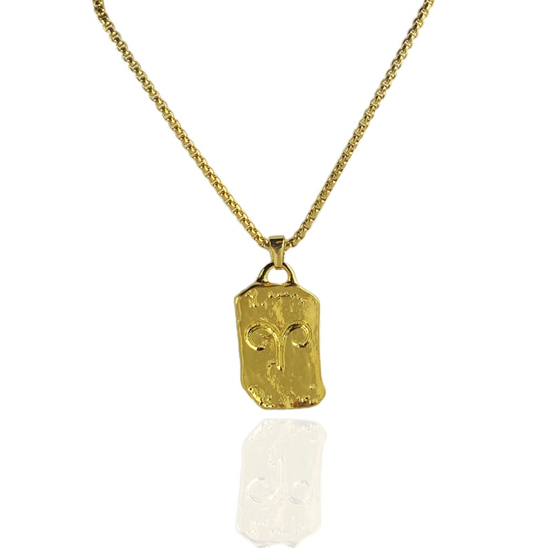 Pu&ograve; includere: Collana con catena dorata e ciondolo dorato con il simbolo zodiacale dell'Ariete.