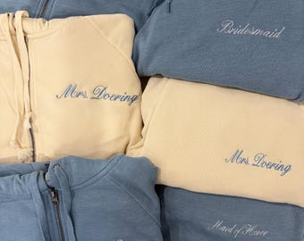 Conjunto de sudadera con capucha y pantalón deportivo con cremallera y bordado personalizado.