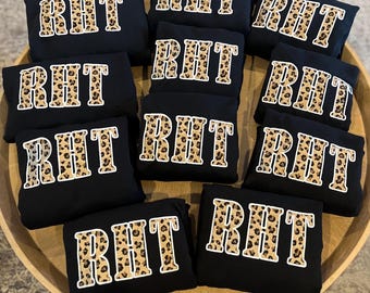 以下が含まれることがあります： レオパード柄の白い文字「RHT」がプリントされた黒いスウェットシャツが10枚です。