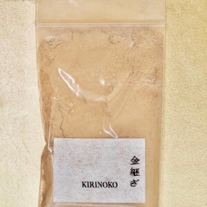 Może przedstawiać: Przezroczysty plastikowy woreczek wypełniony jasnobrązowym proszkiem. Woreczek ma białą etykietę z tekstem "KIRINOKO" i japońskimi znakami "金箔" (Kinpaku, oznaczającymi złoto w płatkach) nadrukowanymi na niej.