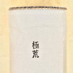 May include: White ceramic cylinder with a black inscription that reads "樹音" on the front.