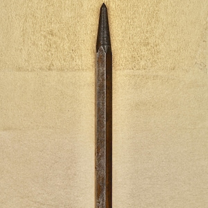 Pode incluir: Um close-up de um furador de metal enferrujado com uma ponta pontiaguda.