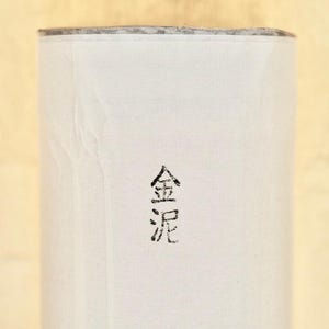 May include: White paper tube with a black ink stamp that reads "金泥".