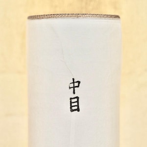 May include: White cylindrical container with a brown top and the word "中目" written in black on the front.