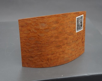 Laminated post card on edge. Buyer must choose lacewood or figured maple.