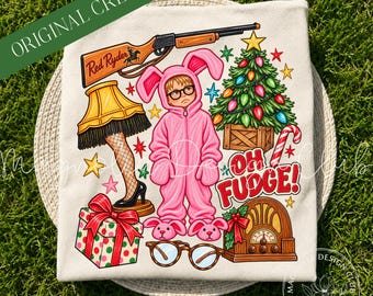 May include: A cream-colored t-shirt featuring a graphic print of a child in a pink bunny suit, a Red Ryder rifle, a leg lamp, a decorated Christmas tree, a gift box, a vintage radio, and glasses with the text OH FUDGE!