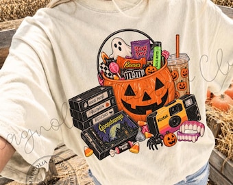 May include: A cream-colored t-shirt featuring a graphic print of a jack-o'-lantern bucket filled with candy, a stack of VHS tapes labeled Hocus Pocus, Halloween, Beetlejuice, and Goosebumps, a Kodak camera, a drink cup, and vampire teeth.
