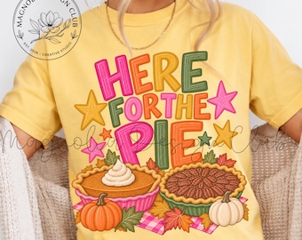 May include: A yellow short-sleeve t-shirt featuring the text "HERE FOR THE PIE" in colorful, bold letters. The graphic includes two pies, one with whipped cream, two pumpkins, autumn leaves, and stars. A circular logo reads "MAGNOLIA DESIGN CLUB".