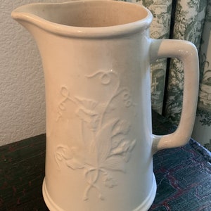 Tall Vintage Wm. Adams & Sons Ironstone China Pitcher; Floral Design in Relief on Sides; Minor Staining; Crazing Throughout. No Chips/Cracks
