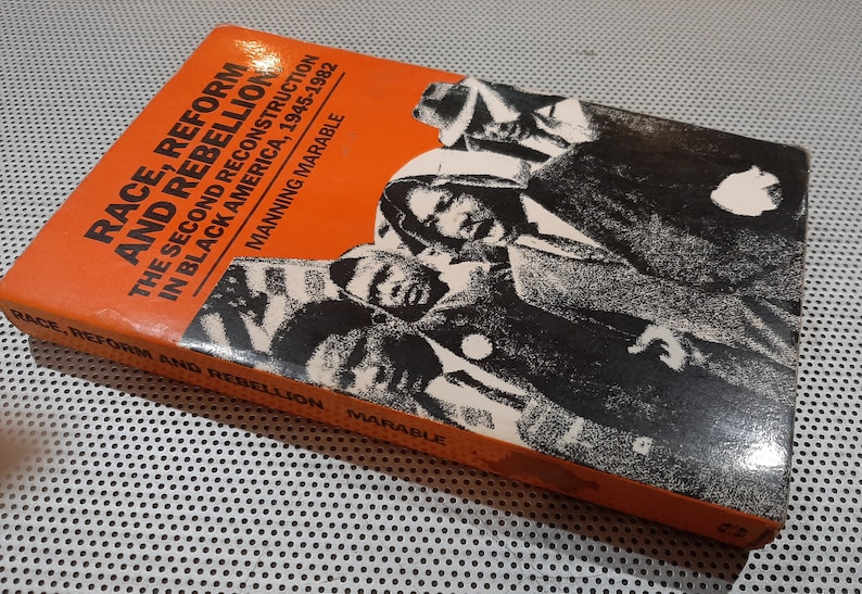 Op de afbeelding: Een boek getiteld "Race, Reform and Rebellion: The Second Reconstruction in Black America, 1945-1982" door Manning Marable. De omslag toont een zwart-witfoto van een groep Afro-Amerikanen.