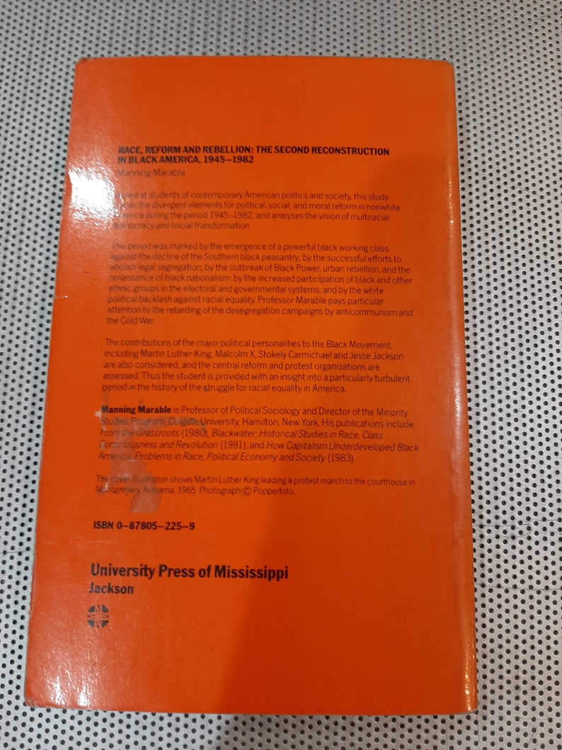 Op de afbeelding: Een rode boekomslag met de titel "Race, Reform and Rebellion: The Second Reconstruction in Black America, 1945-1982" door Manning Marable. De boekomslag bevat ook het ISBN-nummer 0-87805-225-9 en de uitgever University Press of Mississippi.