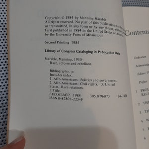 Op de afbeelding: Een boek getiteld "Race, Reform and Rebellion" van Manning Marable. Het boek is in 1984 uitgegeven door de University Press of Mississippi. De omslag van het boek bevat de copyrightinformatie, de catalogiseringsgegevens van de Library of Congress en de inhoudsopgave.