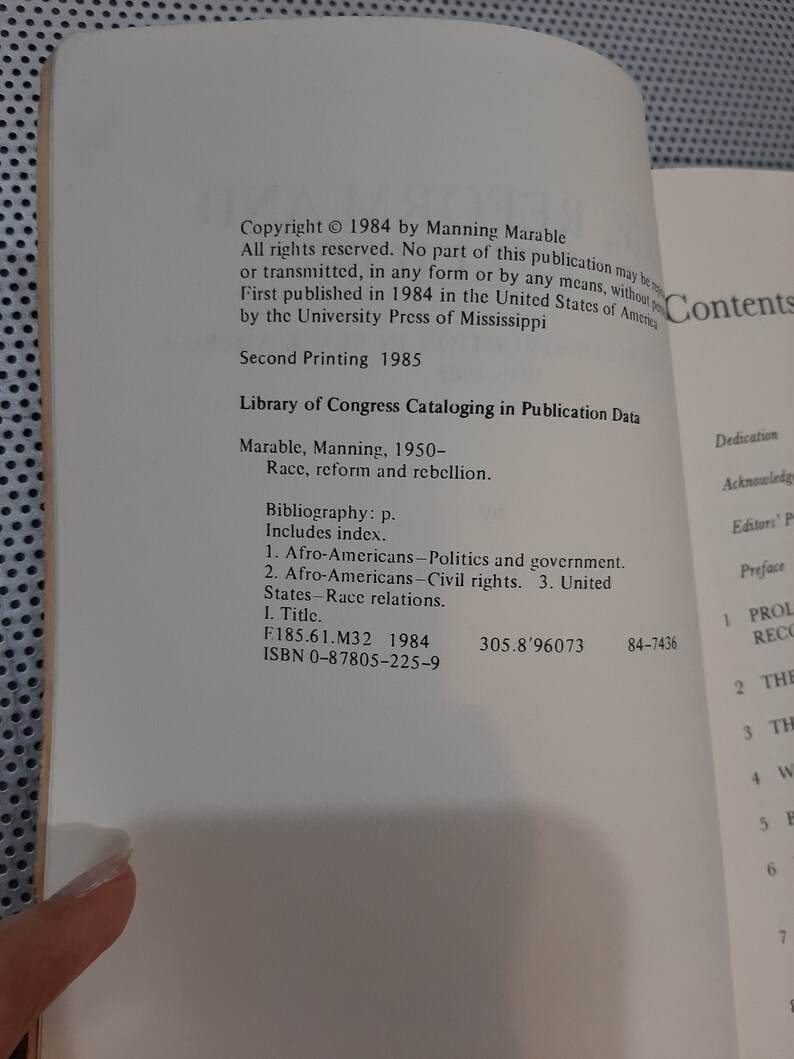 Op de afbeelding: Een boek getiteld "Race, Reform and Rebellion" van Manning Marable. Het boek is in 1984 uitgegeven door de University Press of Mississippi. De omslag van het boek bevat de copyrightinformatie, de catalogiseringsgegevens van de Library of Congress en de inhoudsopgave.