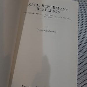 Op de afbeelding: Boekomslag met de titel "Race, Reform and Rebellion: The Second Reconstruction in Black America, 1945-1982" door Manning Marable. De omslag is wit met zwarte tekst.