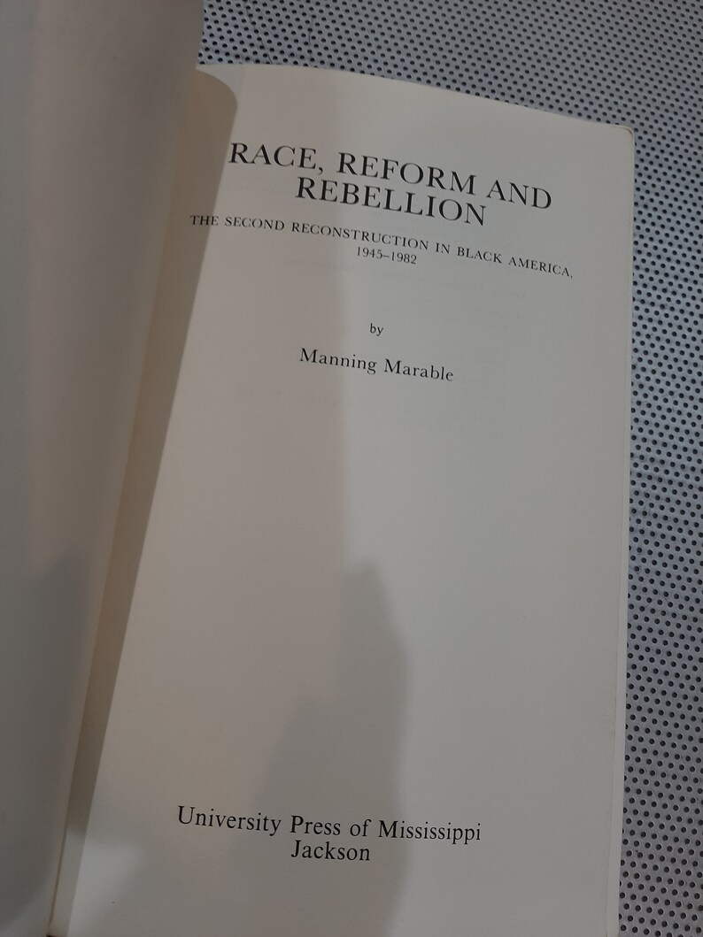 Op de afbeelding: Boekomslag met de titel "Race, Reform and Rebellion: The Second Reconstruction in Black America, 1945-1982" door Manning Marable. De omslag is wit met zwarte tekst.