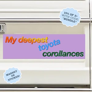 May include: A rectangular bumper sticker or magnet with a light purple background featuring the text My deepest in orange, toyota in blue, and corollances in green. The design is displayed on the white tailgate of a vehicle with red taillights.