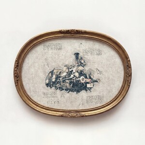 May include: An oval, gold-colored framed print featuring a detailed sketch of a vintage steam train. The artwork is in shades of blue and gray, with architectural-style notes surrounding the train. The frame has ornate detailing.