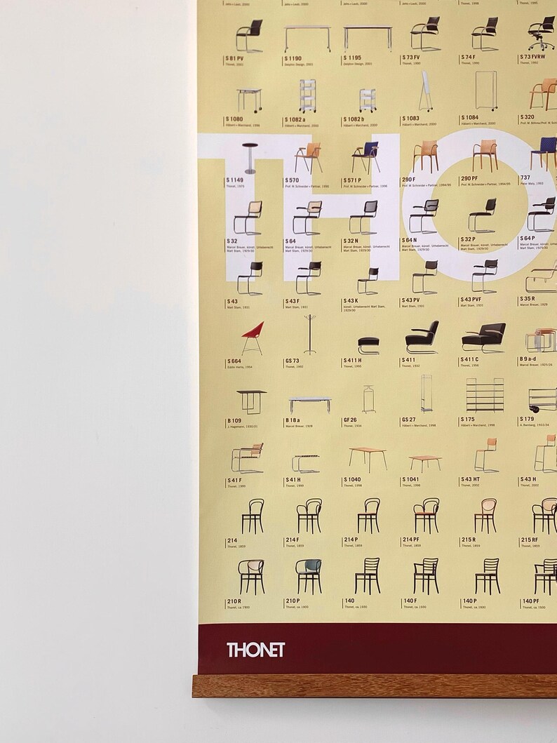 Op de afbeelding: Een poster met een catalogus van Thonet-stoelen, met verschillende ontwerpen en modellen. De poster heeft een houten lijst en is aan een witte muur bevestigd. Het Thonet-logo is onderaan zichtbaar.