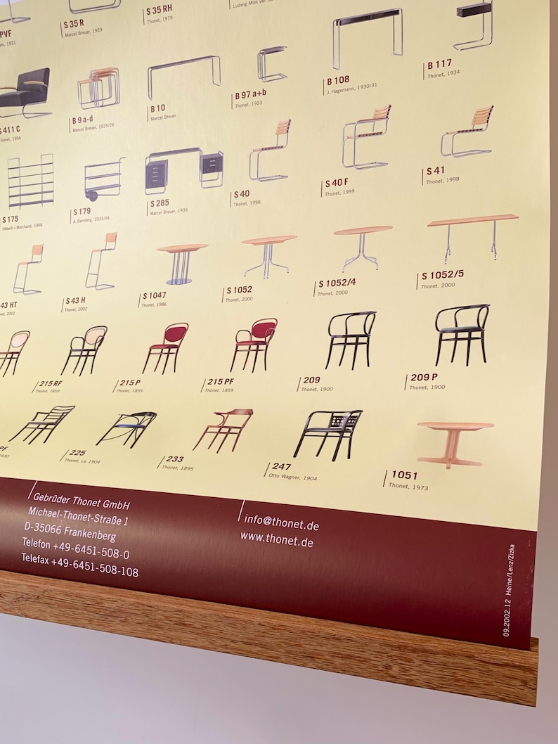 Op de afbeelding: Een poster met een verzameling vintage meubelontwerpen, waaronder stoelen, tafels en bureaus. De ontwerpen worden gepresenteerd in een raster met modelnummers en data. De poster heeft een houten lijst en bevat de contactgegevens van het bedrijf.