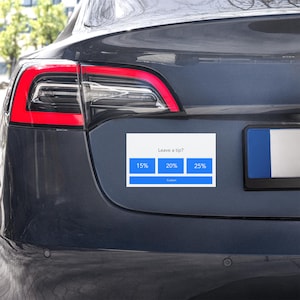 Könnte beinhalten: Ein weißes Rechteck mit dem Text „Leave a tip?“ und Schaltflächen für Trinkgeldbeträge von 15 %, 20 % und 25 % ist am Heck eines dunkelgrauen Autos angebracht. Das Rücklicht des Autos ist sichtbar, mit roter Umrandung.