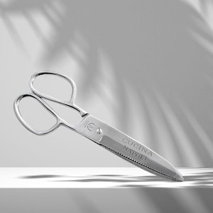 May include: Silver kitchen shears with a serrated blade and the text "Cucina Napoli" engraved on the handle.