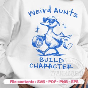 May include: White sweatshirt featuring a blue illustration of a duck wearing sunglasses and carrying tape. The text "weird AUNTS BUILD CHARACTER" is above and below the duck graphic. The bottom of the image shows "File contents: SVG - PDF - PNG - EPS".