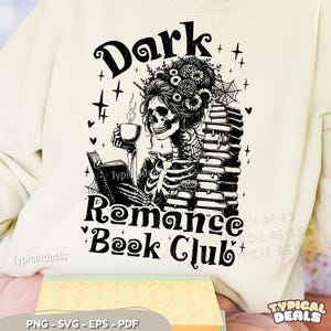 May include: Cream-coloured sweatshirt featuring a black graphic of a skeleton reading and drinking coffee, with the text "Dark Romance Book Club". Decorative elements and the text "Typicaldeals" are also present in the image.