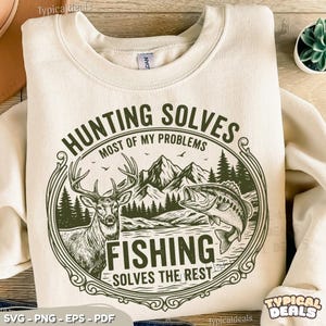May include: Cream-colored sweatshirt with a graphic that reads "HUNTING SOLVES MOST OF MY PROBLEMS, FISHING SOLVES THE REST." The design features a deer, fish, mountains, and trees in a circular frame. The sweatshirt has a crew neck.