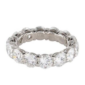 May include: A platinum eternity band featuring a row of round brilliant cut diamonds.