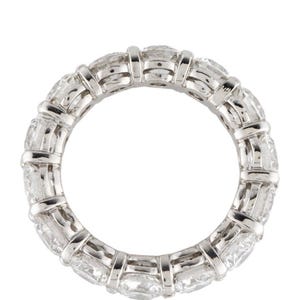 May include: A platinum eternity band featuring a row of round brilliant diamonds set in a pave setting.
