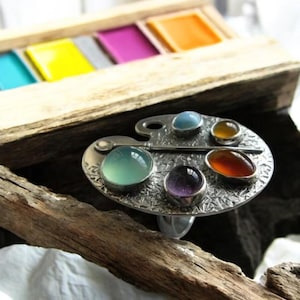 Anillo geométrico ovalado de plata con incrustaciones de piedras de colores, ajustable y llamativo para mujer.