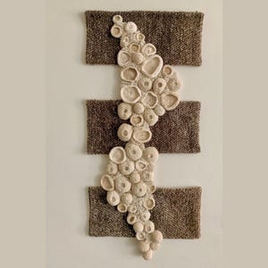 Hanging tapestry, with crochet and embroidery volume on the divided support, in beige.