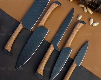 May include: A set of six kitchen knives with dark blades and wooden handles. The blades have a textured finish. The handles are light brown with a dark end cap. A brown leather sheath is visible in the background.