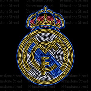 May include: A rhinestone-studded design of a football team logo with a crown on top. The logo is in shades of blue, white, and gold.