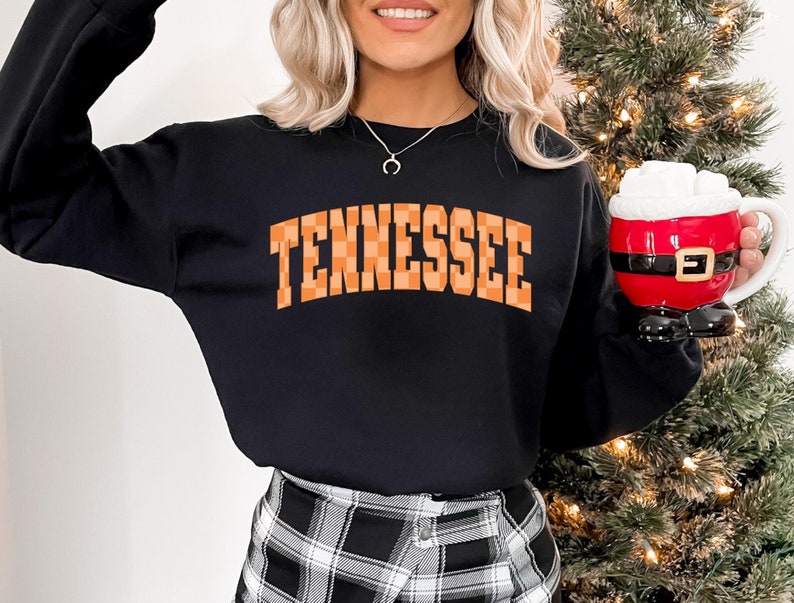 a woman holding a cup of coffee in front of a christmas tree